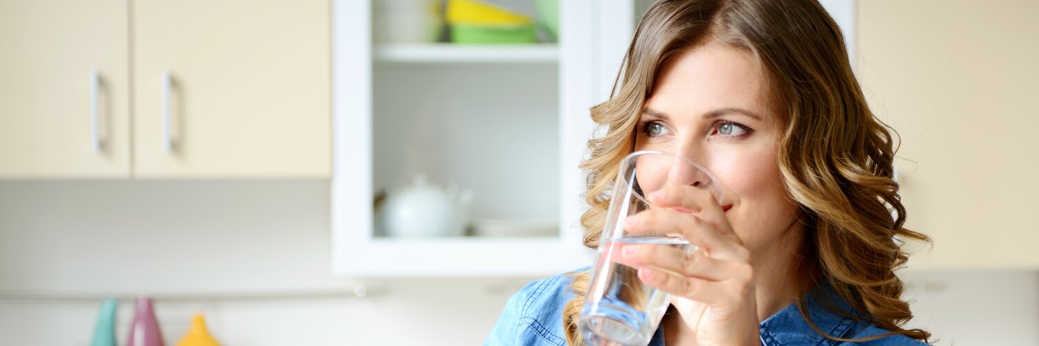 Eine Frau trinkt ein Glas Wasser