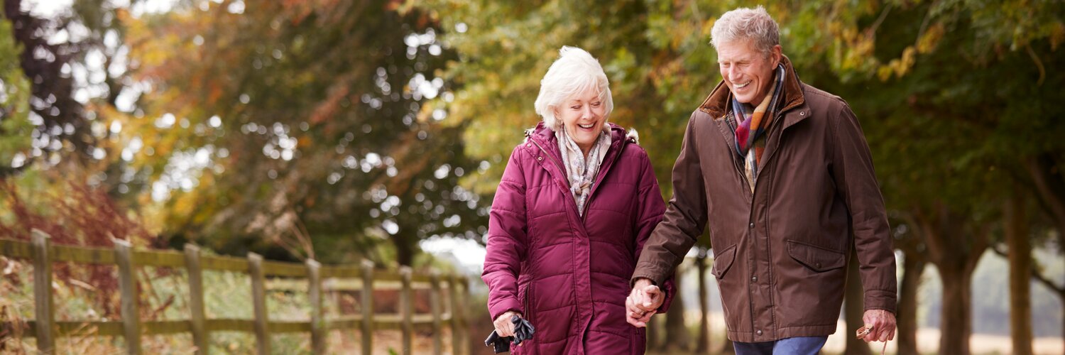 Älteres Paar geht mit ihrem Hund spazieren