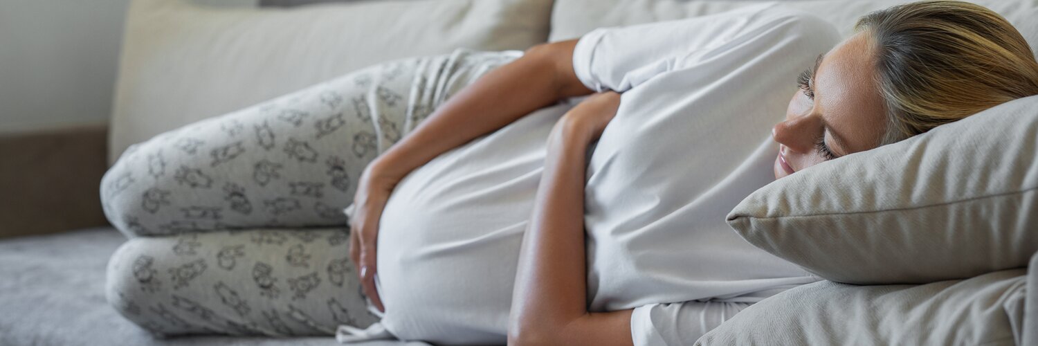 Schwangere Frau schläft auf dem Sofa