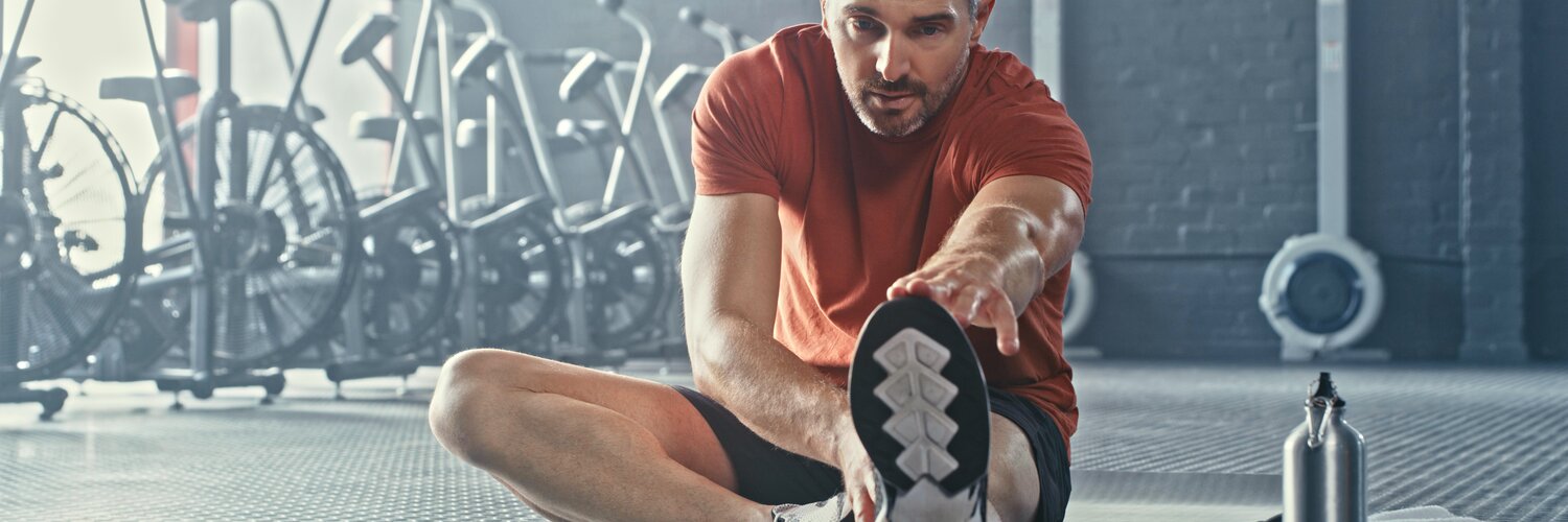 Mann dehnt sich nach dem Sport zur Regeneration