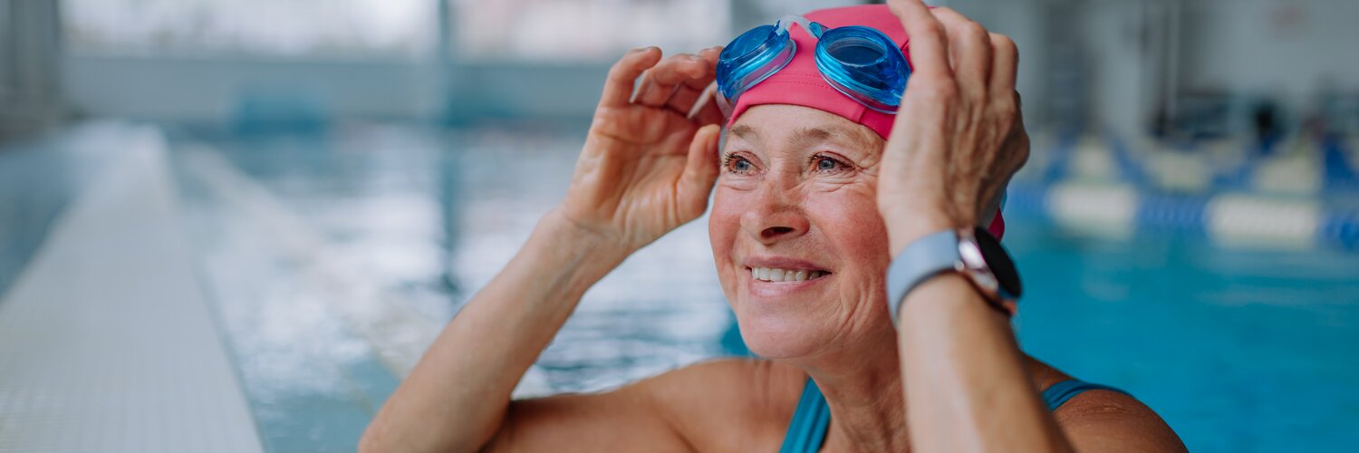 Schwimmerin ruht sich am Beckenrand aus