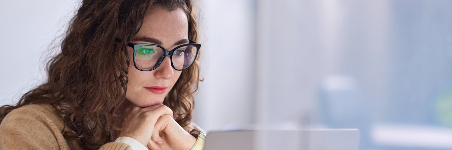 Junge Frau arbeitet fokussiert am PC