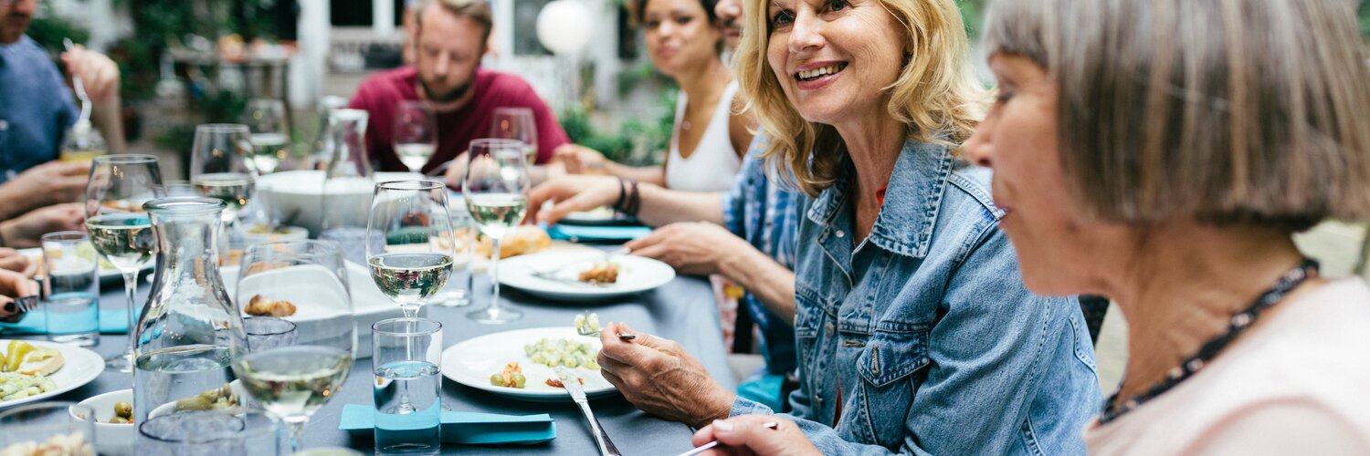 Freunde sitzen draußen zusammen beim Essen
